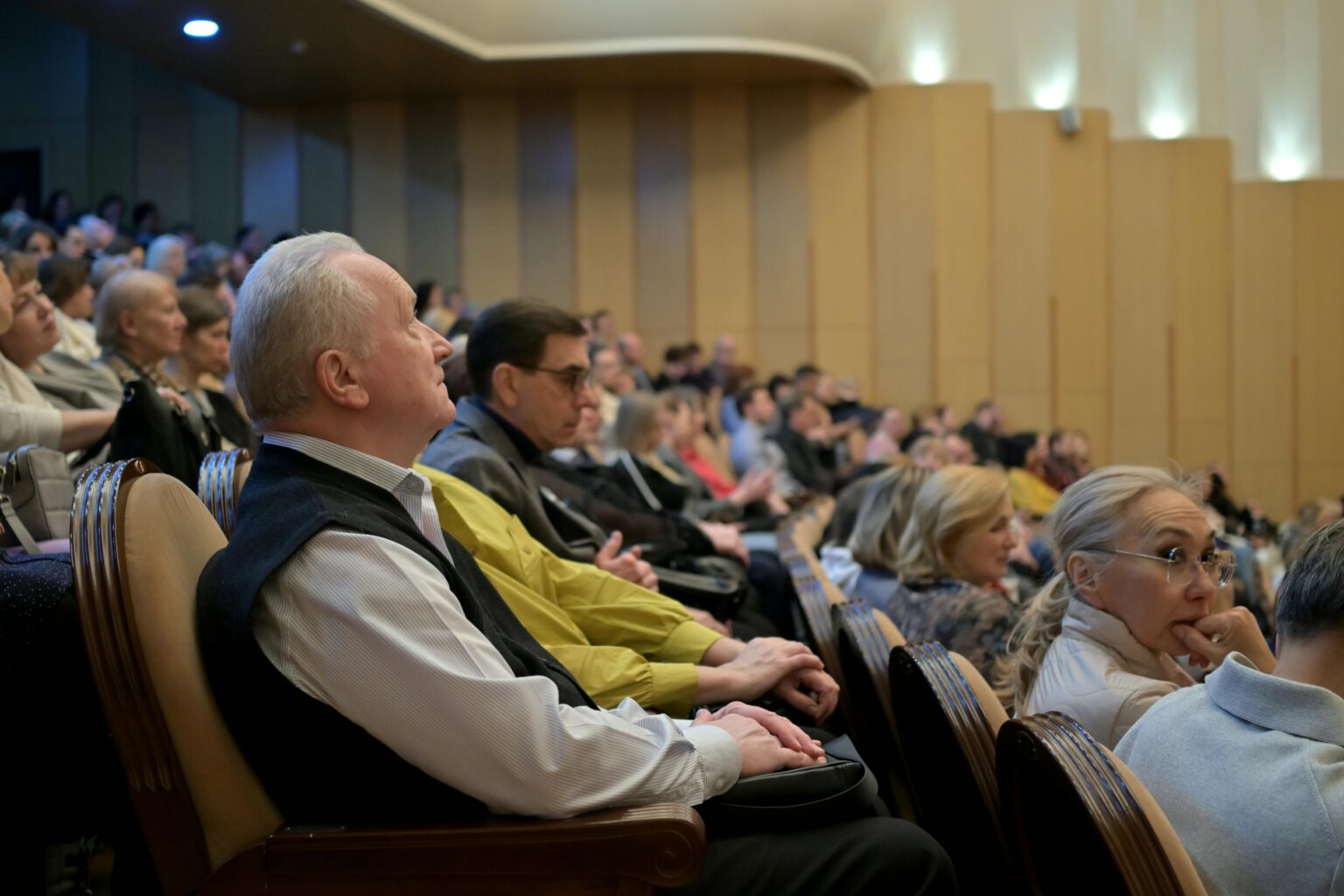 Home A diverse audience attentively listening during a conference in an auditorium.