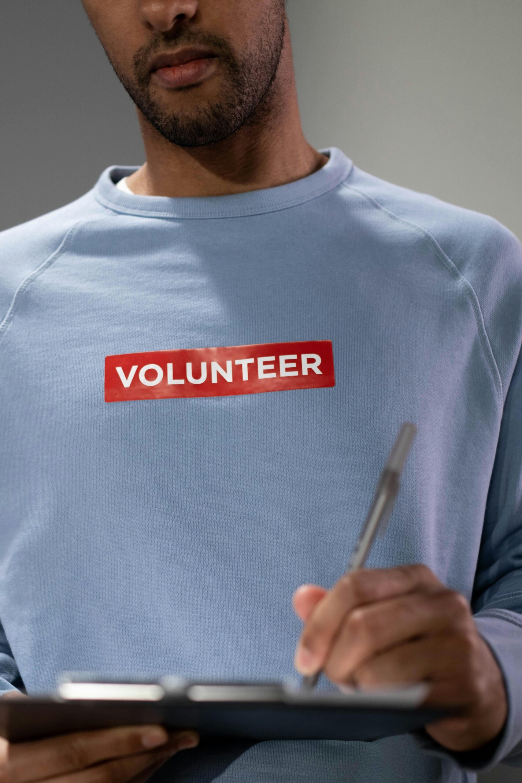 Close-up of a volunteer writing notes indoors, emphasizing community service.