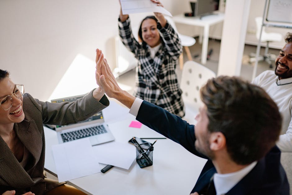 Business team exchanging a joyful high five in a modern office environment.