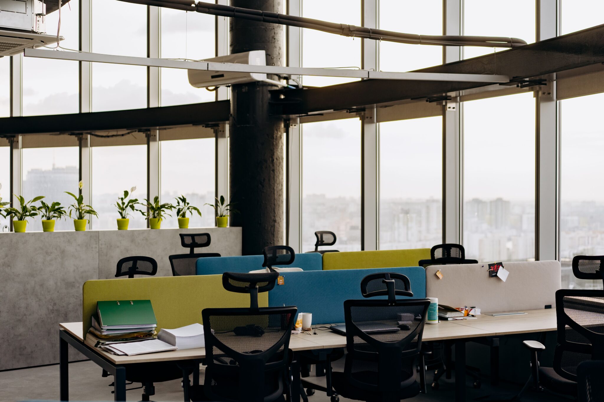 Build the Base A spacious open office with colorful dividers, large windows, and a cityscape view, perfect for creative work environments.